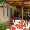 Due persone sedute a un tavolo sotto un portico fiorito.