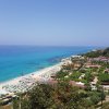 Vista panoramica di una costa con spiaggia e mare azzurro.