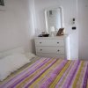 Camera da letto con letto a fantasia e comò bianco.