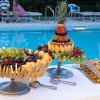 Buffet di frutta decorata accanto a una piscina.