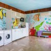 Lavanderia colorata con murales di pesci tropicali sulle pareti.