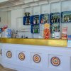 Bancone di un bar con bottiglie e snack esposti.