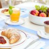 Colazione con cornetto, caffè, succo e frutta.