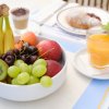 Ciotola di frutta fresca e bicchiere di succo d'arancia.