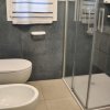 Bagno moderno con doccia e sanitari bianchi.