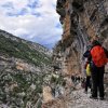 Escursionisti camminano su una stretta pista montana.