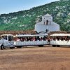 Un trenino bianco vicino a una chiesa.