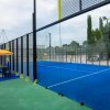 Un campo da padel all'aperto con recinzioni in vetro.