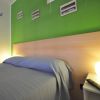 Camera con parete verde, letto matrimoniale e illuminazione soffusa.