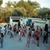 Gruppo di persone che ballano all'aperto su una piattaforma circondata da alberi.
