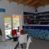 Un bar con tavoli e sedie bianche, decorato con piastrelle blu.