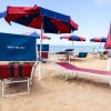 Lettini e ombrelloni blu e rossi sulla spiaggia.