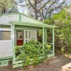 Bungalow tra gli alberi con veranda verde.