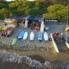 Tavole da surf e barca a vela sulla sabbia.