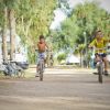 Due bambini in bici su un sentiero alberato in campeggio.