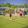 Ragazzi giocano a calcio su un campo all'aperto.