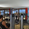 Palestra con vista mare, persone su tapis roulant.