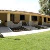 Struttura a schiera con porticati e giardino curato.