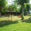 Un parco giochi con altalene e scivoli colorati su un prato verde.