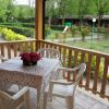 Tavolo con sedie su terrazza vista giardino verde.