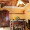 Sala da pranzo con tavolo e sedie in legno, ventilatore a soffitto e armadio.