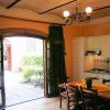 Cucina con tavolo e porte aperte verso un cortile con piante.