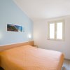 Camera da letto con letto matrimoniale e copriletto arancione.