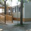 Casa mobile con rampa di legno accessibile, circondata da alberi.