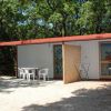 Una casa prefabbricata con sedie e tavoli esterni.