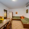 Sala con due divani verdi e tavolo con fiori.