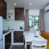 Cucina moderna con tavolo bianco e divano giallo.
