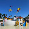 Nave giocattolo colorata con scivoli in una piscina bassa.