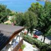 Vista sul mare, albero e terrazza con piante.