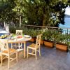 Terrazza con tavolo, sedie e vista sul mare.