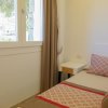 Letto singolo vicino a finestra luminosa.