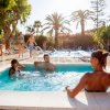 Persone in piscina e vasca idromassaggio all'aperto.