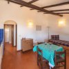 Cucina con tavolo e divano sotto travi a vista.