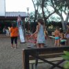 Parco giochi con bambini che giocano su una giostra e uno scivolo.