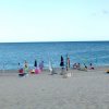 Spiaggia affollata con persone in riva al mare.