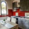 Cucina moderna con pareti rosse e tavolo con sedie bianche.