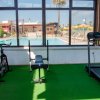 Palestra con cyclette, panca e tapis roulant, vista su piscina.