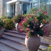 Vasi di terracotta con fiori colorati disposti su gradini davanti a un edificio in pietra.