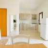 Cucina minimalista con mobili in legno e frigo bianco.