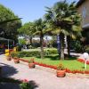 Giardino con aiuole di fiori e palme vicino a un edificio giallo.