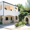 Villa bianca con portico e forno a legna esterno.