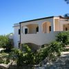 Villa bianca immersa nel verde con terrazza e vista.