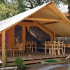 Tenda da campeggio con veranda e sedie in legno.
