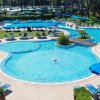 Piscina con sedie a sdraio e ombrelloni blu.