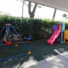 Area giochi per bambini con scivolo e altalena.