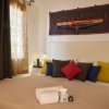 Una camera da letto accogliente con cuscini colorati e asciugamani piegati sul letto.
